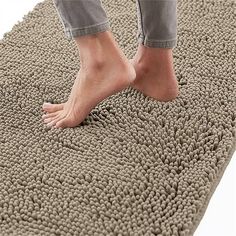 a person standing on top of a gray rug