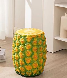 a pineapple shaped stool sitting on top of a hard wood floor