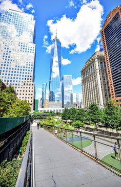 the walkway is surrounded by tall buildings and trees