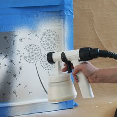 a person is using a blow dryer to spray paint