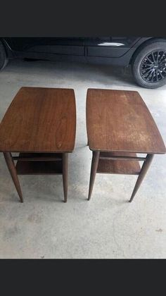 two wooden tables sitting next to each other in front of a black car on the street