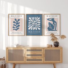 two framed art prints hang on the wall next to a wooden sideboard in a living room