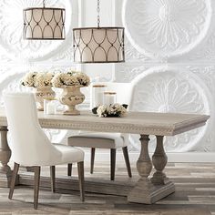 a dining room table with white chairs and chandelier