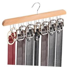 a wooden hanger with several belts hanging from it's hooks and two pairs of belt