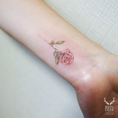 a small rose tattoo on the wrist