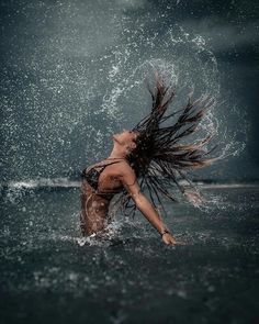 a woman in the water splashing her hair