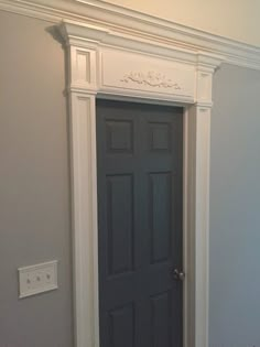 an empty room with a black door and white trim