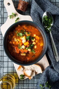 a bowl of soup with bread and parsley on the side