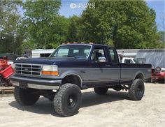 a black truck parked on top of a dirt field