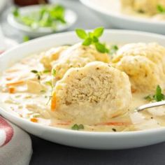 two white bowls filled with soup and dumplings