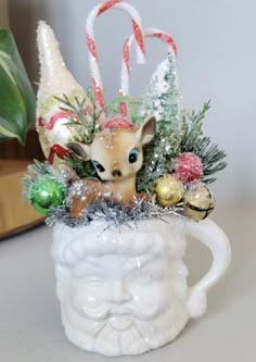 a small deer in a mug with christmas decorations