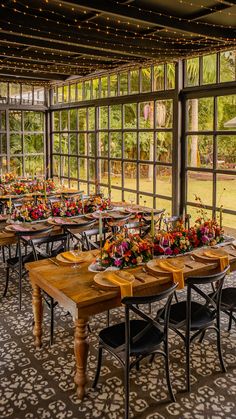 an indoor dining area with many tables and chairs set up for a formal function in front of large windows