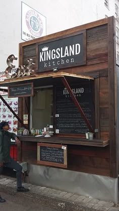 a man walking past a kiosk on the street