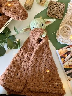 a crocheted baby yoda doll laying on top of a table next to other items