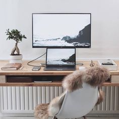 a laptop computer sitting on top of a wooden desk next to a white leather chair