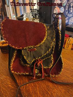 This small satchel is made using high quality wine colored Bison and black Deer leather. On the front is a nice sized pocket and above that is a Mahogany Obsidian needle from Davis Creek, California. Inside are two smaller pockets for extra storage. It comes with an adjustable cross body shoulder strap. All of the leather is treated with an all natural professional stain guard & water repellent. Approximately 9 inches (22.9 cm)by 8.5 inches (21.6 cm) by 3 inches (7.6 cm). Burgundy Leather Satchel For Fall, Fall Burgundy Leather Satchel, Red Leather Festival Bag, Red Leather Bohemian Satchel, Red Bohemian Leather Satchel, Bohemian Red Leather Satchel, Leather Satchel With Adjustable Strap For Festivals, Black Deer, Bison Leather