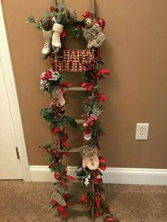 a christmas wreath hanging on the side of a wall next to a ladder decorated with stockings and poinsettis