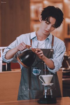 a man in an apron pours coffee into a cup