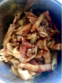 a blue bowl filled with pasta and meat