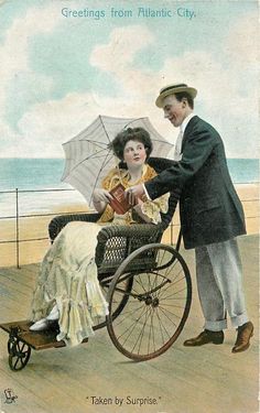 an old photo of a man pushing a woman in a stroller on the beach