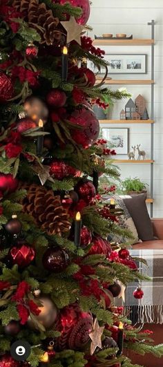 a christmas tree decorated with red and gold ornaments, pine cones, candles and other holiday decorations