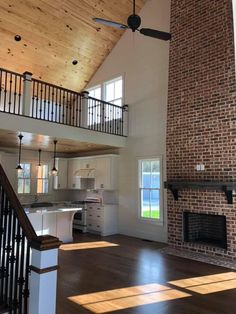 an empty living room with brick fireplace and open floor to ceiling windows on the second floor