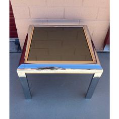 a small mirrored table sitting in front of a brick wall