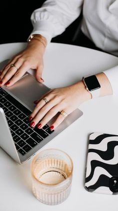 a woman is typing on her laptop computer