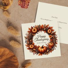 two greeting cards with autumn leaves and pumpkins on them, sitting next to each other