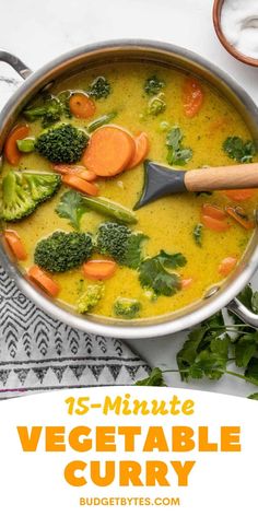 a pot full of vegetable curry with broccoli and carrots on the side