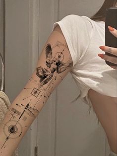 a woman with a tattoo on her arm taking a selfie