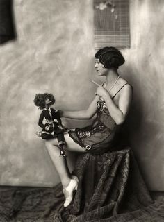 a woman sitting on top of a bed holding a teddy bear