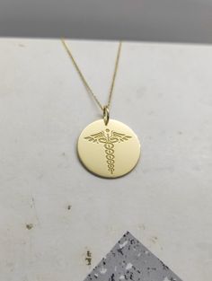 WE SHIP ALL PARCELS IN ONE BUSINESS DAY FOR FREE AND PROVIDE THE SPEEDIEST DELIVERY! Engraved Nurse Design Necklace - Medical Pendant Necklace - Handmade Nurse Gold Jewelry - Engraved Nurse Gold Necklace Engraved Nurse Pendant Necklace made out of 14K Solid Gold. Available only in Yellow Gold finish. An elegant piece of jewelry that is a perfect gift to yourself and your loved ones. Charm Thickness: 0.5mm Jump Ring inner diameter: 4mm Add your engraved personalization at the back of the pendant. Customizable Gold Necklace With Round Pendant, Customizable 14k Gold Pendant Jewelry, Customizable Yellow Gold Round Pendant Jewelry, Customizable Yellow Gold Round Pendant Necklace, Customizable Yellow Gold Round Pendant, Customizable Yellow Gold Anniversary Necklace, Personalized Symbolic Necklaces For Commemoration, Personalized Symbolic Necklace For Commemoration, Symbolic Personalized 14k Gold Jewelry