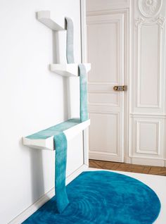 a blue rug in the corner of a room with a white wall and door behind it