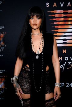 a woman with long black hair and tattoos on her chest, posing for the camera