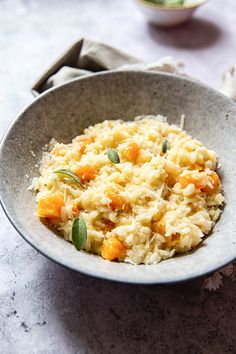 a bowl filled with rice and carrots on top of a table next to a napkin