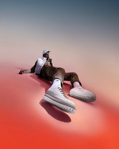 a man laying on the ground with his feet up and wearing white tennis shoes in front of him