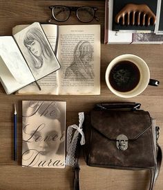 an assortment of books, glasses and a purse on a table