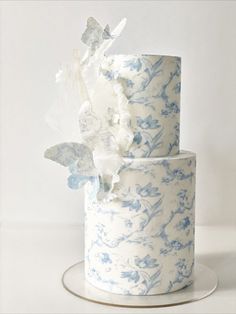 a three tiered cake with blue and white flowers on it