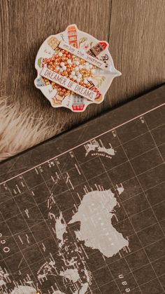 a world map is shown on the floor next to a cutting board with some food in it