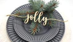 a plate with pine branches and the word merry on it