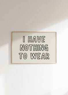 i have nothing to wear sign hanging on the wall in front of a white wall