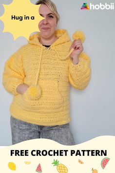 a woman wearing a yellow crochet hoodie with the words hug in a bubble above her head