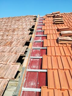 the roof is covered with red tiles and wooden planks