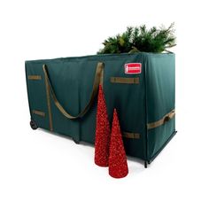 two christmas trees in a green bag with gold trimmings on the bottom and one red cone next to it