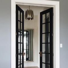 an open door leading to another room with wood flooring and walls painted in gray