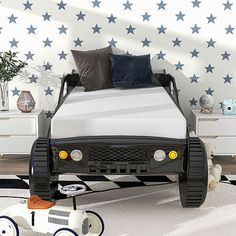 a child's bedroom with a toy car bed and stars on the wall behind it