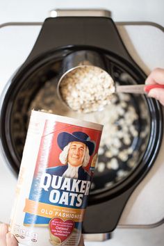 a person holding up a bag of oatmeal in front of an electric stove