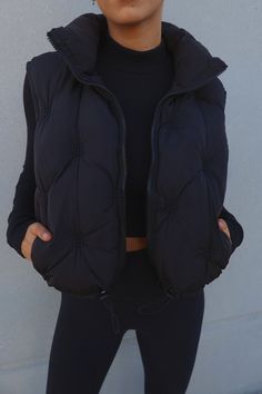 DETAILS: Our Quilted Crop Puffer Vest is a cropped length puffer vest with a quilting design. This black puffer vest features a collared neckline, full zip closure, and functional pocket detail. The hem is completed with a cinch-cord with a draw cord. This puffer vest is very lightweight has a slightly oversized fit which makes it perfect for layering. This vest is true to size. CONTENT & CARE: SELF: 100% Polyester LINING: 100% Polyester SIZE & FIT: Model is 5'6" The model is wearing a size S/M Crop Puffer Vest, Pilates Princess, Black Puffer Vest, Comfy Clothes, Black Puffer, Women Clothes, Puffer Vest, Pocket Detail, Comfy Outfits