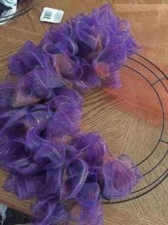 purple mesh wreath sitting on top of a wooden table